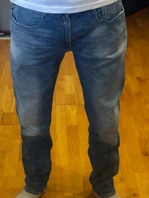 Blåa replay Anbass jeans - Mörkblå jeans med ljus tvätt från Replay, modell Anbass, i storlek W33 L32. Jeansen är i extremt bra skick, nästan som nya – slitningarna är en del av designen. Slim fit-passformen visas av personen på bilden som är cirka 182 cm. Nypris ligger på 1700 kr.  Kolla gärna in profilen också, där finns flera märkeskläder och skor – du hittar säkert något mer som passar 😉💯 Hör av dig om du undrar något!