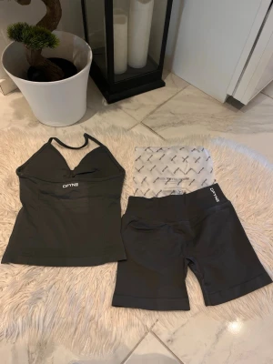 Slate gray DFYNE - Säljer ett snyggt grått träningsset från DFYNE med sport-bh/topp med vadderade kupor och matchande cykelbyxor. Materialet är stretchigt och följsamt, perfekt för gymmet eller yoga. Setet har diskret logga på både topp och byxor.
