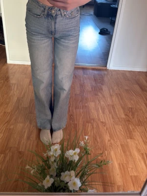 Ljusblå raka jeans - Säljer ett par ljusblå raka jeans med klassisk femficksdesign och hög midja. Jeansen har en snygg tvättad look och är tillverkade i denim. Fine en liten defekt, men syns inte så mycket. Perfekta för dig som gillar en avslappnad och trendig stil.