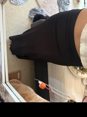 Svart lång kjol i ribbat material med slits - Säljer en svart långkjol med ribbat tyg och hög midja. Kjolen har en figurnära passform och är gjord i ett stretchigt material som sitter snyggt längs kroppen. Perfekt att styla med en crop top eller stickad tröja.