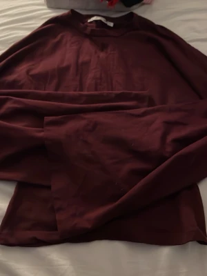 Mörkröd cropped sweatshirt - En enkel och stilren mörkröd sweatshirt med rund hals och större armar Perfekt att matcha med jeans eller mjukisbyxor. Materialet känns mjukt och bekvämt mot huden.