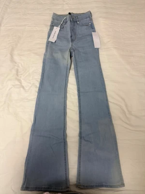Ljusblå bootcut jeans från NA-KD - Säljer ett par helt nya jeans från Bubbleroom. Jeansen är som ny, aldrig använd och prislapp finns kvar. Jeans köptes för 499kr och är i storlek 34.