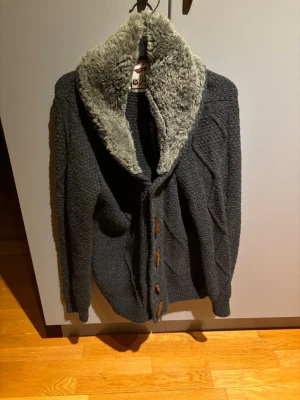 Stickad cardigan med pälskrage  - Tja! Säljer min cardigan då de närmar sog varmare tider. Storlek M passar mig på 193/74kg bra. Hör av dig vid funderingar!