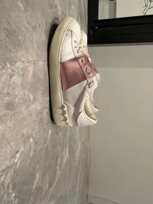 Valentino Garvani - Snygga vita Valentinos med rosa detaljer & bitar i bak. Givetvis äkta. Box medföljer ej. Skick 6/10 kontakta mig vid frågor eller följande. 