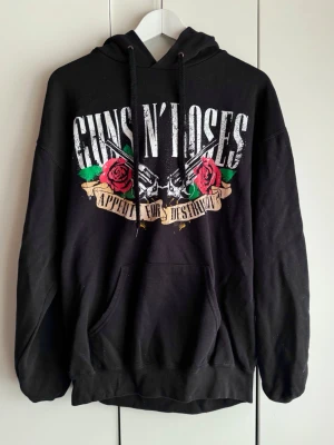 Guns N' Roses svart hoodie. L. EMP Shop. - Svart hoodie med stor Guns N' Roses-tryck både fram och bak. 'Appetite for Destruction'. Klassisk känguruficka och justerbar huva med snören. Mjuk o go. Storlek L. Inköpt på EMP shop. Fruit of the Loom. Perfekt för dig som gillar rock och vill sticka ut.  Lite använd. Fint skick. 