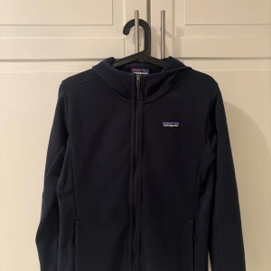 Patagonia Fleece zip med luva - Marinblå Patagonia Fleece zip med luva i mycket bra skick! Nästan oanvänd! Storlek M, Färg Marinblå