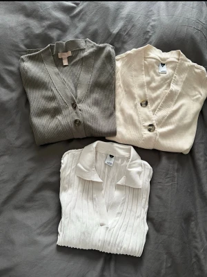 3 stycken Beige ribbad tröjor med knappar - Säljer tre stycken ribbad kofta/ tröjor från med tre stora dekorativa knappar framtill. Koftan har lång ärm, smal passform och djup v-ringning.  Alla 3 för ett pris