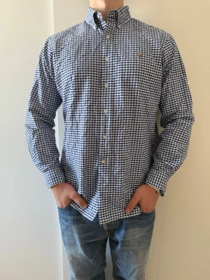 Blårutig skjorta från Ralph Lauren - Klassisk blårutig skjorta från Ralph Lauren, skick som ny, Inget att anmärka. Riktigt snygg för layering eller bara ha som den är
