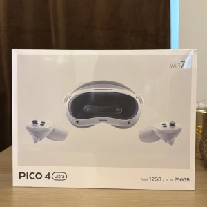 Pico 4 Ultra VR-headset 12GB/256GB - Pico 4 Ultra VR-headset med 12GB RAM och 256GB lagring. Snygg vit design med svarta detaljer och två ergonomiska handkontroller. Perfekt för gaming och VR-upplevelser. Kompatibel med WiFi 7 för snabb anslutning.