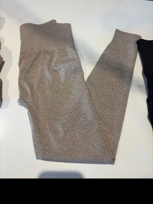 Beige seamless leggings med hålmönster - Snygga beige seamless tights  med hög midja och hålmönster längs benen. Stretchigt material som sitter skönt och formar sig efter kroppen. Perfekta för dig som vill ha både stil och komfort i vardagen.