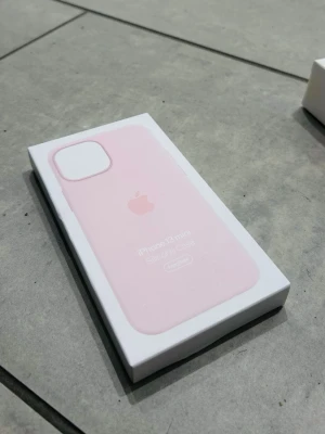 Ljusrosa Apple iPhone 13 mini skal - Snyggt ljusrosa silikonskal från Apple till iPhone 13 mini. Skalet har en stilren design med Apple-loggan på baksidan och är tillverkat i mjukt silikon som ger bra grepp och skydd. Perfekt för dig som vill ha ett enkelt men trendigt mobilskal.