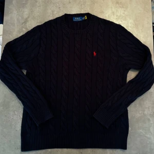 Polo ralph Lauren Navy knit wear jumper  - Kabelstickad mörkblå tröja från Polo Ralph Lauren med rund halsringning och röd broderad logga på bröstet. äkta från zalando (har email) använt max 8 gånger storlek M 