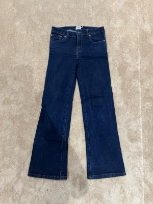 Bootcut jeans från 157 i mörkblå denim - Säljer ett par mörkblå bootcut jeans från 157 med klassisk 90-talsvibe. Jeansen har fem fickor, hög midja och utsvängda ben. Tillverkade i kraftig denim med kontrastsömmar. Perfekta för dig som gillar retrostilen!