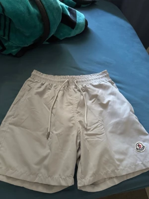 Gråa badbyxor från Moncler - Bra moncler shorts säljs precis i samma tyg som under armour och står vid storlek L men är fasktist som M och aldrig nånsin använts 