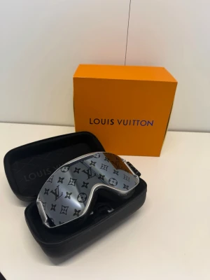 LV snow skidglasögon  - Toppskick  skidglasögon i en supersnygg silver/grå modell med det ikoniska Monogram-mönstret över linsen. Perfekta för vintersäsongen eller som en lyxig detalj i skidbacken! * Skick: Endast använda en gång * Medföljer: Originalbox, skyddsfodral 100% äkta. Skickas spårbart och packas mycket varsamt. Svarar gärna på frågor eller skickar fler bilder vid förfrågan! 🌟