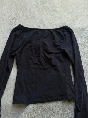 Mörk marinblå croppad långärmad topp - Säljer en mörk marinblå, croppad långärmad topp med bred urringning. Toppen har en slim passform och är tillverkad i mjukt bomullsmaterial. 