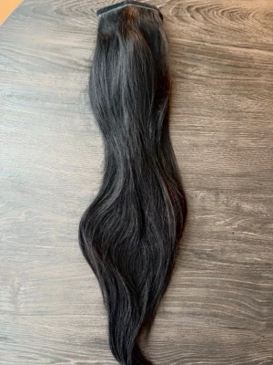 Ponytail äkta löshår 50cm svart - Säljer en ponytail löshår i äkta hår som går att färga, locka och platta etc. Endast använd 1 gång så för en uppsättning, väldigt fint skick. Enkel att sätta fast med spännet i håret och linda runt slingan för att dölja.   Färg: Svart Mått: 50cm Vikt: Cirka 110 gram 