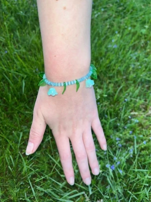 Armband med blommor - Superfint armband med turkosa glaspärlor och hängande blommor o blad. Passar handled XS-S.         Köp två armband för 60kr ✨