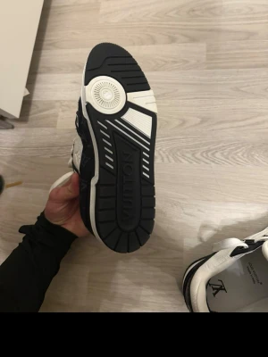 Louis Vuitton  sneakers - Snygga sneakers från Louis Vuitton i svart och vitt med klassiskt monogrammönster på sidorna. Skorna är endast använda 2 gånger och jag lämnar tillbaka dem eftersom jag köpt ett nytt par. Kvitto och original paket tillkommer. Köpta September 2025 från LV. Skorna passar mig som är storlek 43 och upp o ner en halv storlek. 