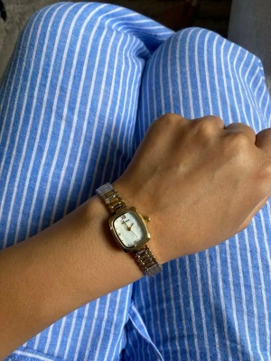 Guldfärgad fyrkantig klocka rostfritt stål justerbar - Stilren guldfärgad klocka med fyrkantig urtavla och metallarmband. Urtavlan är vit med minimalistiska markeringar och gulddetaljer. Perfekt accessoar för dig som gillar klassisk och elegant stil.