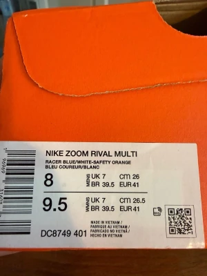 Nike Zoom Rival Multi spikskor blå storlek 41 helg nya oanvända nypris 1000kr - Nike Zoom Rival Multi spikskor i racerblå med vit och orange swoosh. Skorna har en lätt och ventilerande mesh-överdel samt greppvänlig sula med inslag av grönt och orange. Perfekta för friidrott och träning på bana.