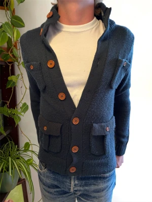 *Unik* Stickad Cardigan med Knappar - En mycket trevlig stickad cardigan i en lite dovare marinblå färg, mest sanningsenlig på första bilden. Hör av dig vid frågor! 