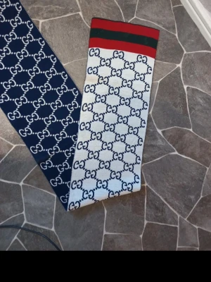 Gucci halsduk med GG-mönster - Gucci halsduk: Ren har använts vissa gånger väldigt bilig tycker jag helt ny kostar runt 1500-2000kr. Det är bra nu för vintern och den kalla kylan.  PRIS KAN DISKUTERAS! jag har inte kvar paketet tyvär eftersom jag köpte den som nyaste jätte längesen och att den är använd 1-3 gånger jag vet inte riktigt hur jag ska bevisa att den är äkta men du kan jämföra med andra halsdukar som är gucci  Jag vet själv den är äkta 100%! Tillverkad i Italien.