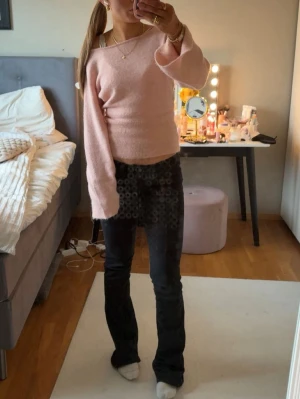 Ljusrosa stickad tröja med vida ärmar - Supersöt ljusrosa stickad tröja med breda, långa ärmar och lätt croppad passform. Tröjan har en mjuk och skön känsla, rund halsringning och sitter snyggt på kroppen. Perfekt för dig som gillar en feminin och trendig look.