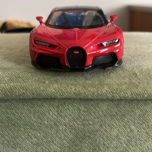  Röd svart Bugatti Chiron  -  Svart röd Bugatti Chiron, perfekt för bilälskare samt småbarn med intresset av bilar Den här bilen har en roller back start