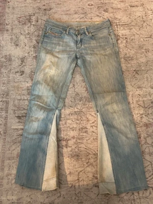 Ljusblå utsvängda jeans från Diesel - Säljer ett par jätte snygga vintage diesel jeans som är utsydda. Midjemått är 38cm rakt över och innerbenslängd är 75cm. de har tecken på användning längst ner eftersom de är lite smutsiga. de är för små därav att jag säljer dem! 💕