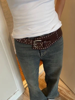 Brunt nitarbälte med silverdetaljer - Säljer mitt super snygga bruna bälte med nitdetaljer. Bältet är likt gimaguas bälten. Lyfter upp en tråkig outfit!!💕