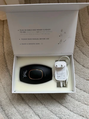 Mandy Skin IPL hårborttagningsapparat laser - Snygg IPL hårborttagningsapparat från Mandy Skin i svart med gulddetaljer. Kommer i originalförpackning med tillhörande strömadapter. Perfekt för smidig hårborttagning hemma. Modern design och enkel att använda.