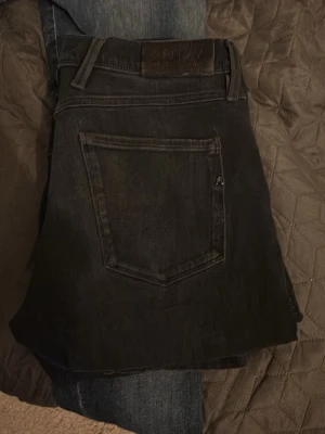 Svarta slim fit jeans från Replay - Säljer ett par svarta slim fit jeans från reaplay Jeans. Klassisk femficksmodell med normal midja och raka ben. Jeansen har en diskret logga på bakfickan och är tillverkade i mjuk denim med lite stretch för extra komfort.