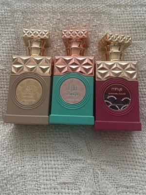 Tre lyxiga parfymer från Minya - Säljer tre exklusiva parfymer från Minya i snygga flaskor med geometriskt mönster och guldfärgade lock. Färgerna är beige, turkos och vinröd. Flaskorna har en lyxig och modern design som sticker ut i badrumshyllan.