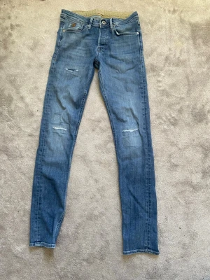 Jack&jones jeans - Säljer ett par blå jack and Jones jeans i storlek 29-32. Jeansen har riktigt snygga slitningar. Jag säljer dessa jeans för 250 kr skriv vid minsta fundering😃👍🤗