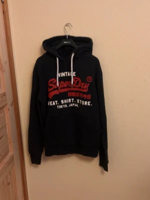 Vintage Superdry Hoodie  - En väldigt snygg Vintage Superdry Hoodie! I väldigt bra skick skulle säga 8/10 🤩 Storlek M men passar även Storlek L 🙌                                      Skriv vid mera frågor/bilder 🤝                                    Fraktar inom 24 Timmar 🚚