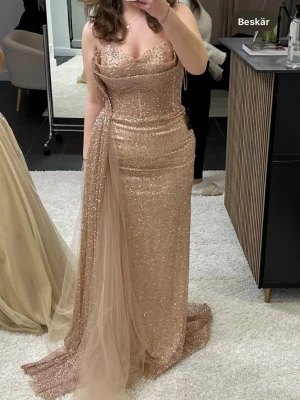 Glittrig balklänning - Säljer nu min gamla balklänning. Klänningen är i mycket gott skick då den endast används i några fåtal timmar vid ett tillfälle. Klänningen är i en storlek 38 och är uppsydd för att passa någon som är mellan 167-175 beroende på hur höga skor som önskas användas. Priset är diskuterbart.