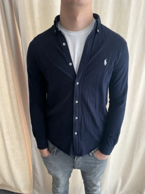 Mörkblå skjorta från Ralph Lauren - Riktigt snygg skjorta från Polo Ralph Lauren i nästan nyskick. Strl M, personen på bilden är 184 cm lång. Skicka gärna prisförslag. Kika in min profil för liknande plagg 