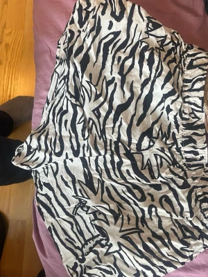 Zebramönstrade shorts från H&M Divided - Säljer ett par zebramönstrade shorts från H&M Divided i svart och vitt. De har elastisk midja och är tillverkade i mjuk viskos som känns skön mot huden. Perfekta för dig som vill sticka ut lite extra i sommar!