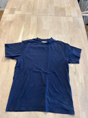 Mörkblå basic t-shirt från Ljung  - En stilren mörkblå t-shirt från Ljung i mjuk bomull. Klassisk passform med rund halsringning och korta ärmar. Perfekt till jeans eller shorts för en enkel och clean look.