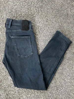  slim fit jeans från replay - Snygga mörkblå slim fit jeans från replay med klassisk femficksdesign och diskret logga på bakfickan. Jeansen har normal midja och smala ben, tillverkade i mjukt denimtyg med stretch för extra komfort.
