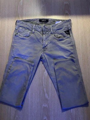 Replay grå jeans med raka ben - Snygga grå jeans från Replay med klassisk femficksmodell och raka ben. Jeansen har svarta detaljer vid fickan och en svart patch bak i midjan. Tillverkade i mjukt denimtyg som ger en avslappnad men stilren look.