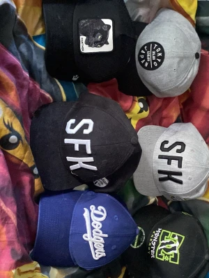Blå Dodgers keps med brodyr - Snygg blå keps med vit Dodgers-brodyr framtill. Klassisk böjd skärm och justerbar baksida. Perfekt för dig som gillar sportig stil och vill ha en ikonisk accessoar till vardagslooken.* 🐆 Goorin Bros “Panther” svart trucker: ca  300 kr * ⚫ SFK svart: ca 50–150 kr * ⚪ SFK grå: ca 50–150 kr * 🔵 Dodgers blå: ca 100–250 kr * ⚫🟢 DC/Monster Energy svart: ca 150–250 kr * ⚪⚫ Tokyo Japan grå/svart: ca 50–150 kr     Och 550 för allt 