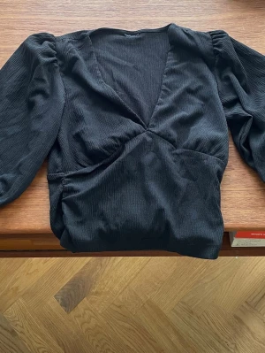 Svart croptop med halvlång ärm - Svart djupt V ringad sexig croptop med halvlång ärm. Ursnygg med pushup bh.