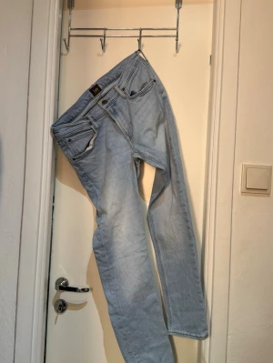 Ljusblå Luke jeans från Lee - Säljer ett par ljusblå jeans från Lee, modell Luke. Jeansen har klassisk femficksdesign, raka ben och är tillverkade i mjuk bomullsdenim med lite stretch. Perfekta för en avslappnad och trendig look.