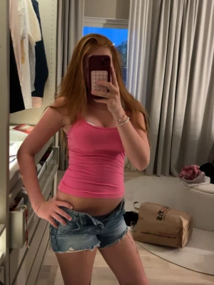 Blå denimshorts med fransar - Snygga blå denimshorts med råa franskantade benslut och klassisk femficksdesign. Lågmidjade och i en loose passform, perfekta för sommaren. Passar till allt och ger en avslappnad vibe.