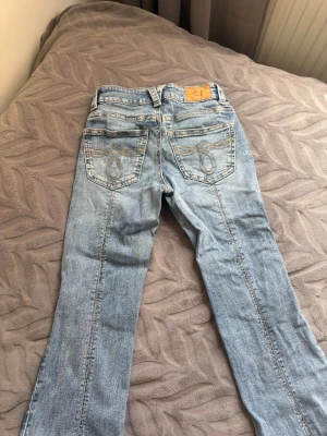 Perfect Jeans Gina tricot bootcut - Säljer ett par ljusblå bootcut jeans från Gina Tricot med snygga kontrastsömmar och broderade bakfickor. Klassisk femficksmodell i mjuk denim med låg midja och utsvängda ben. Perfekta för dig som gillar en avslappnad men trendig stil. Använd fåtal gånger i mycket bra skick och inga defekter!! Längd 32 och XS. Pris går att diskutera💞