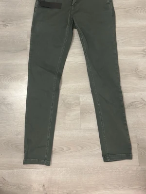 Gröna chinos från Replay Hyperflex - Snygga gröna chinos från Replay Hyperflex med klassisk passform och dragkedjegylf. Byxorna är handgjorda i Italien och har en stretchig känsla för extra komfort. Perfekta för dig som vill ha stilrena och bekväma byxor med modern look.