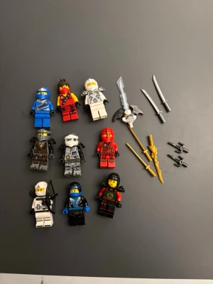 Lego Ninjago figurer och vapen - Säljer ett set med nio Lego Ninjago minifigurer i olika färger och stilar samt flera tillhörande vapen som svärd, stavar och kaststjärnor. Figurerna har detaljerade tryck och tillbehör som hjälmar och masker. Perfekt för dig som gillar att bygga och leka med Lego.