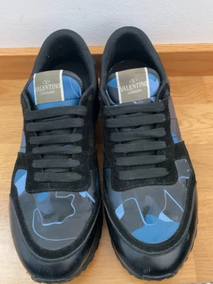 Valentino Rockrunners  - Snygga sneakers från Valentino Garavani med blå och svarta camo-detaljer. Skorna har svarta mocka- och textilpartier, svarta snören. Det kommer med dust bag och extra snören. Pris går att diskutera!!
